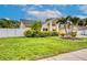 Well-maintained home featuring lush landscaping, mature trees, and a sprawling green lawn at 1592 Cumberland E Ct, Palm Harbor, FL 34683