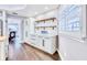 Kitchen with white cabinetry, wooden shelves, and modern finishes at 1592 Cumberland E Ct, Palm Harbor, FL 34683