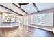Open-concept living room with vaulted ceilings, wood beams, and view of pool through large window at 1592 Cumberland E Ct, Palm Harbor, FL 34683