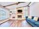 Cozy living room featuring a stone fireplace, wooden ceiling beams, and hardwood floors at 1592 Cumberland E Ct, Palm Harbor, FL 34683
