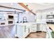 Bright, open-concept space with kitchen island overlooking living area with fireplace and wood-beamed ceiling at 1592 Cumberland E Ct, Palm Harbor, FL 34683