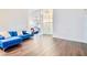 Open-concept living room with hardwood floors, natural light and a blue sofa at 1592 Cumberland E Ct, Palm Harbor, FL 34683