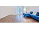 Stylish living room showcasing hardwood flooring, a comfortable blue sofa and bright French doors at 1592 Cumberland E Ct, Palm Harbor, FL 34683