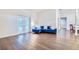 Bright living room featuring hardwood floors, french doors, and a stylish blue sofa at 1592 Cumberland E Ct, Palm Harbor, FL 34683