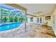 Relaxing screened-in pool area surrounded by lush landscaping at 1592 Cumberland E Ct, Palm Harbor, FL 34683