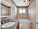 The cozy bathroom features granite vanity, decorative mirror, and tiled bathtub at 1710 Townsend St, Clearwater, FL 33755