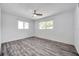 Bright bedroom featuring wood-look flooring, a ceiling fan, and two windows at 1710 Townsend St, Clearwater, FL 33755
