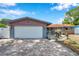 Charming single-story home featuring an attached garage and a brick driveway leading to a well-maintained front yard at 1710 Townsend St, Clearwater, FL 33755