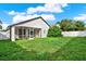 View of the home's screened-in lanai and lush green backyard at 18419 Merseyside Loop, Land O Lakes, FL 34638