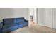 Neutral bedroom featuring a blue sofa bed and a glimpse into an adjacent room at 18419 Merseyside Loop, Land O Lakes, FL 34638