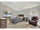 Cozy bedroom features a sliding door to the backyard, a ceiling fan, and neutral decor at 18419 Merseyside Loop, Land O Lakes, FL 34638