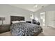 Spacious bedroom with neutral carpeting, a ceiling fan, and an attached bathroom at 18419 Merseyside Loop, Land O Lakes, FL 34638