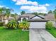 Inviting single-story home with a two-car garage and tropical landscaping at 18419 Merseyside Loop, Land O Lakes, FL 34638