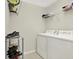 Functional laundry room with white washer and dryer and wire shelving at 18419 Merseyside Loop, Land O Lakes, FL 34638