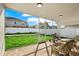Covered patio with wicker furniture overlooks a spacious, fenced backyard at 18419 Merseyside Loop, Land O Lakes, FL 34638