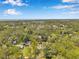 Wide aerial view revealing lush green landscape, neighborhood homes, and distant water views at 2140 Bow Ln, Safety Harbor, FL 34695