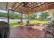 Inviting backyard deck with pergola, ceiling fans, and a grill, overlooking a spacious yard at 2140 Bow Ln, Safety Harbor, FL 34695