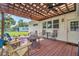 Covered back deck with ceiling fans, ample seating, and views of the expansive backyard space at 2140 Bow Ln, Safety Harbor, FL 34695