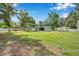 Large backyard featuring a detached garage, workshop, and a privacy fence at 2140 Bow Ln, Safety Harbor, FL 34695