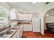 Clean kitchen with white cabinets, a gas stove and views of living room at 2140 Bow Ln, Safety Harbor, FL 34695