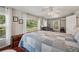 Comfortable main bedroom boasts a large window view, ceiling fan, and a quaint blue and white patchwork quilt at 2140 Bow Ln, Safety Harbor, FL 34695