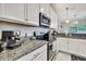 Kitchen featuring granite countertops, stainless steel appliances and white cabinets at 2155 Cerulean Sky Dr, Lutz, FL 33558