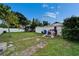 Backyard featuring a large grassy area with shed, covered structure, and white fence at 2334 14Th N Ave, St Petersburg, FL 33713