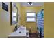 The bathroom has a mirror, white sink and toilet, with bright yellow walls at 2334 14Th N Ave, St Petersburg, FL 33713