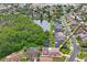 Aerial view showcasing a home nestled in a neighborhood with a serene lake and mature trees at 277 Wood Dove Avenue, Tarpon Springs, FL 34689