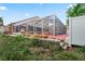 Backyard featuring the pool, patio, and retaining wall leading down to the pond at 277 Wood Dove Avenue, Tarpon Springs, FL 34689