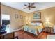 Cozy bedroom featuring a ceiling fan, wooden floors, and a comfortable bed at 277 Wood Dove Avenue, Tarpon Springs, FL 34689