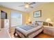 Bedroom with ceiling fan, large window, and light wood floors at 277 Wood Dove Avenue, Tarpon Springs, FL 34689