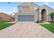Charming home featuring a brick driveway and well-maintained lawn, showcasing its curb appeal at 277 Wood Dove Avenue, Tarpon Springs, FL 34689