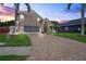 Beautiful home exterior featuring a brick driveway, well-manicured lawn, and a two-car garage at 277 Wood Dove Avenue, Tarpon Springs, FL 34689