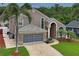 Grand two-story home with a brick driveway and lush landscaping, creating an inviting and sophisticated entrance at 277 Wood Dove Avenue, Tarpon Springs, FL 34689