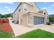 Side view of a two-story home with a brick driveway and well-manicured lawn at 277 Wood Dove Avenue, Tarpon Springs, FL 34689