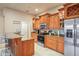 Spacious kitchen features stainless steel appliances, wooden cabinets, granite counters, and tiled floors at 277 Wood Dove Avenue, Tarpon Springs, FL 34689