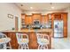 Well lit kitchen with wooden cabinets, granite counters, stainless steel appliances, and a cozy breakfast bar with seating at 277 Wood Dove Avenue, Tarpon Springs, FL 34689
