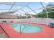 An inviting pool with white screening in the background, and lush trees in the surrounding area at 277 Wood Dove Avenue, Tarpon Springs, FL 34689