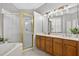 Bright bathroom features double sinks, wood cabinets, a glass-enclosed shower, and a soaking tub at 2772 Golf Lake Dr # 03, Plant City, FL 33566