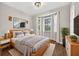 Cozy bedroom with a large bed, gray bedding, lamps, mounted TV, and natural light from two windows at 2772 Golf Lake Dr # 03, Plant City, FL 33566