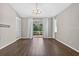 Open living area with hardwood floors, sliding glass doors, white curtains, and a modern chandelier at 2772 Golf Lake Dr # 03, Plant City, FL 33566