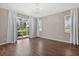 A large living room featuring hardwood floors, glass sliding doors to the backyard, and white curtains at 2772 Golf Lake Dr # 03, Plant City, FL 33566