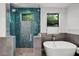 Modern bathroom showcasing a glass-enclosed shower, soaking tub, and windows with lush greenery views at 2803 W Aquilla St, Tampa, FL 33629