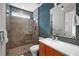 Modern bathroom featuring blue mosaic tile accent wall, walk-in shower, glass door, vanity, and undermount sink at 2803 W Aquilla St, Tampa, FL 33629