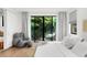 Bedroom featuring hardwood floors, a plush chair and floor lamp, and a scenic view framed by large windows at 2803 W Aquilla St, Tampa, FL 33629
