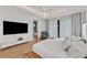 Bright bedroom featuring hardwood floors, modern fixtures, a large bed, and seamless flow to an ensuite bathroom at 2803 W Aquilla St, Tampa, FL 33629
