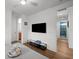 Modern bedroom with a flatscreen television, sleek glass shelf, and ensuite bathroom entrance with bright, natural light at 2803 W Aquilla St, Tampa, FL 33629