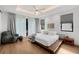 Spacious bedroom featuring hardwood floors, a modern platform bed, large windows with curtains, and a stylish chair at 2803 W Aquilla St, Tampa, FL 33629