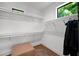 Bright walk-in closet with white wire shelving, hardwood floors, and natural light from a window at 2803 W Aquilla St, Tampa, FL 33629